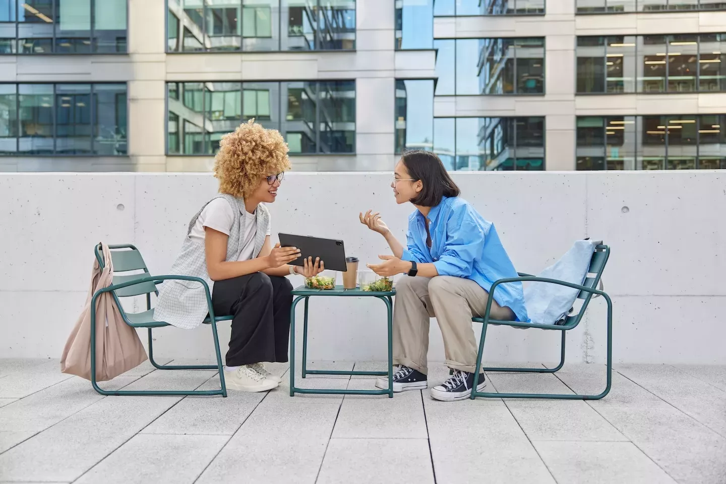 Dos personas sentadas y hablando afuera