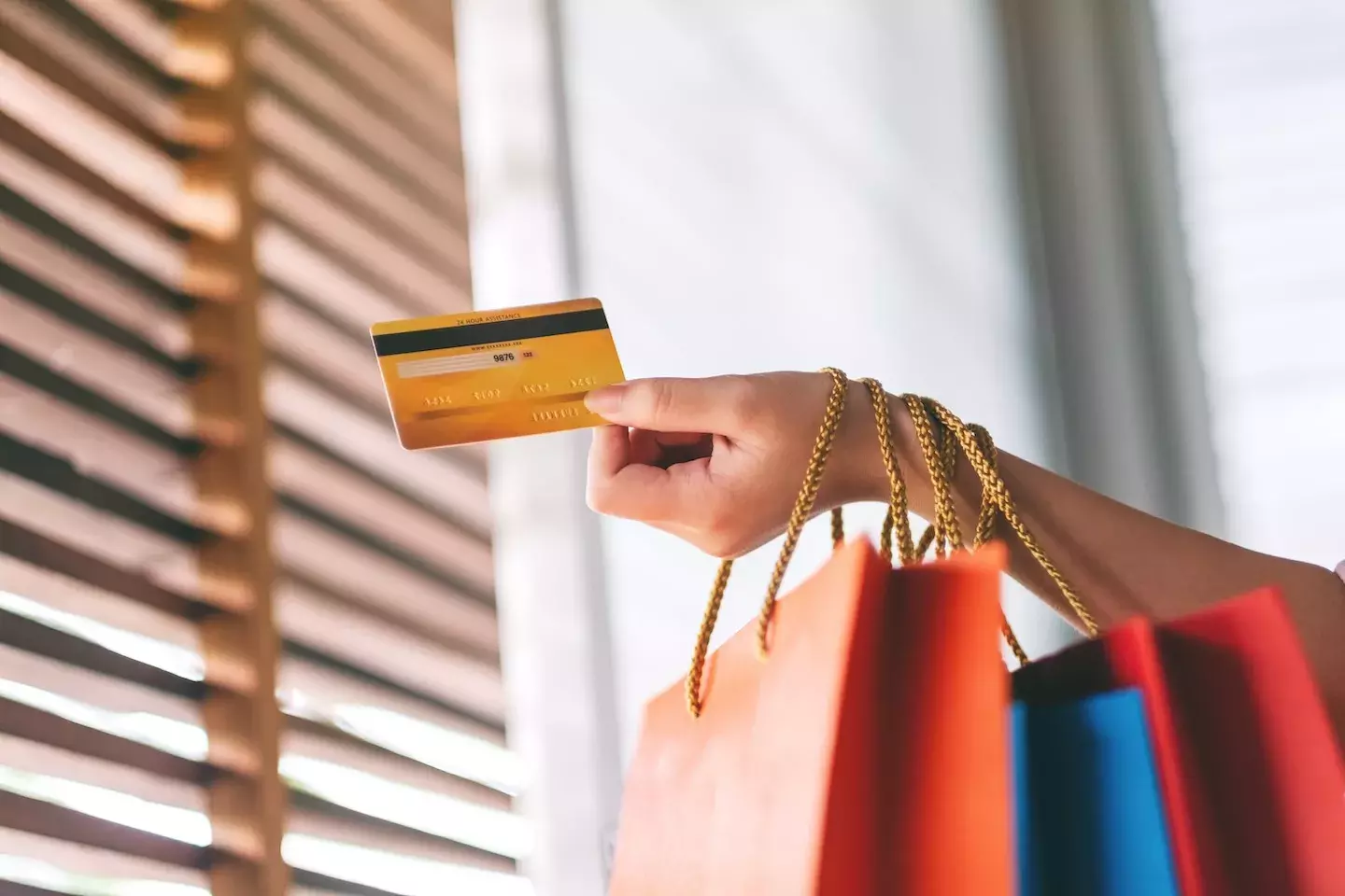 person holding a credit card and shopping bags