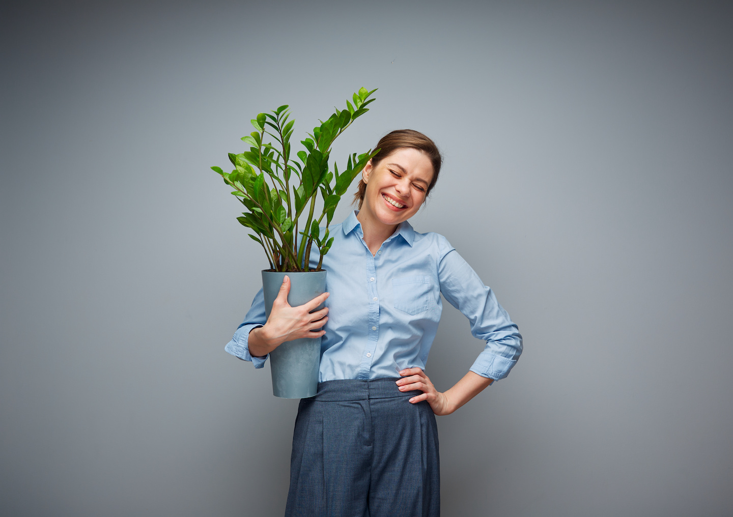 Business woman holding large houseplant