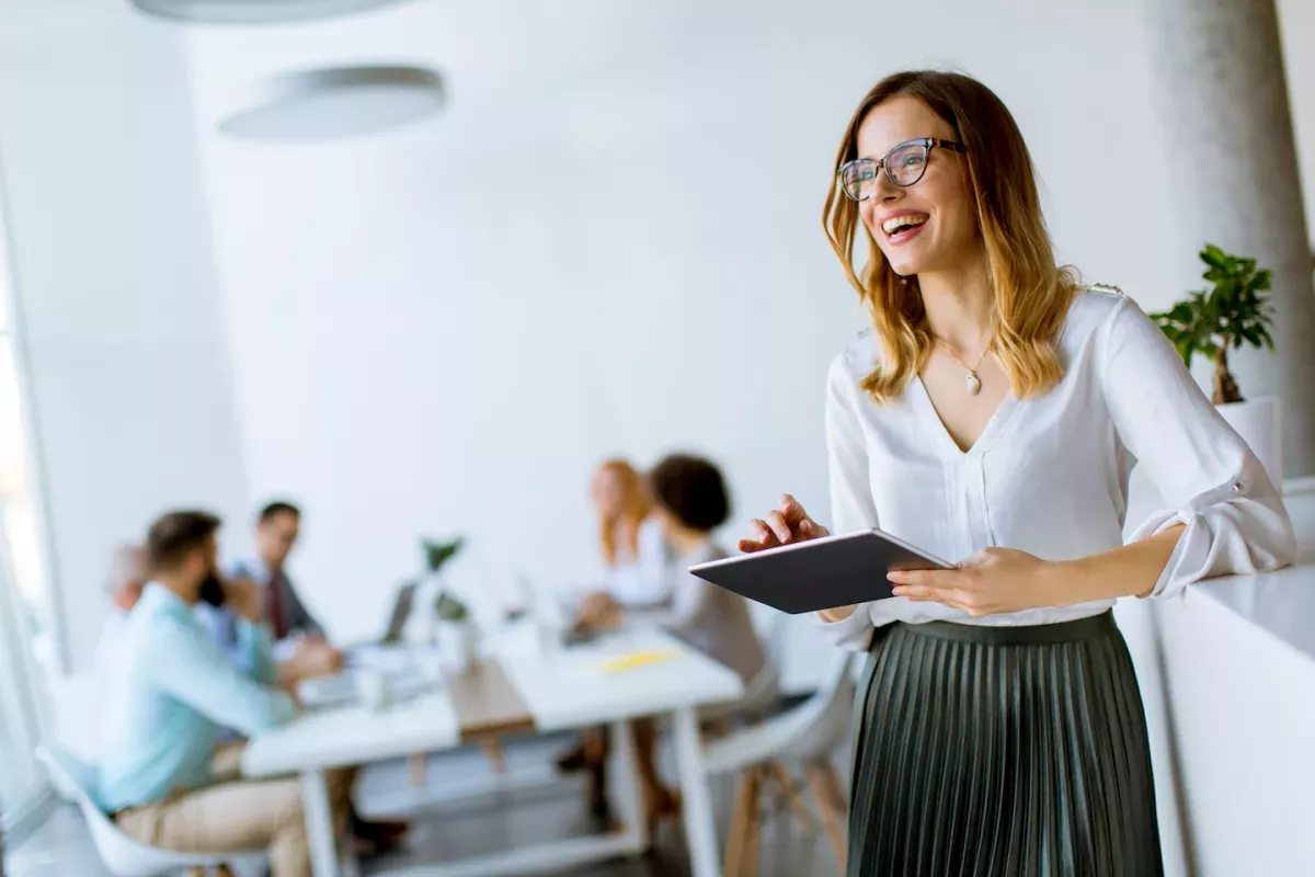 AdobeStock_243346877.jpeg Woman working in an office and smiling