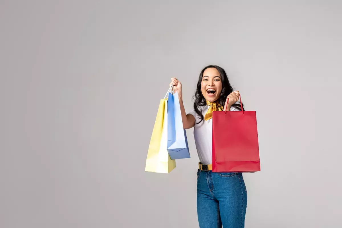 AdobeStock_246435733.jpeg Happy woman holding shopping bags