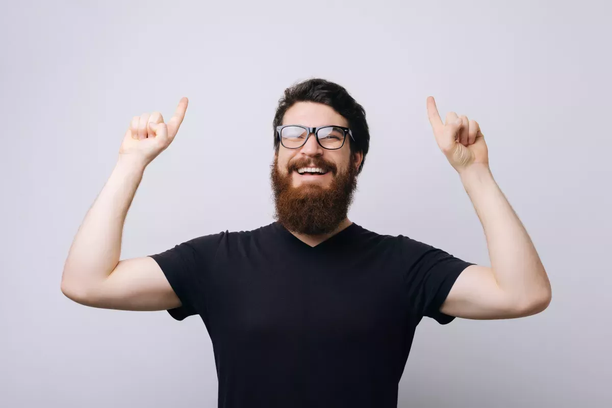 AdobeStock_248211890.jpeg smiling man pointing up with both hands