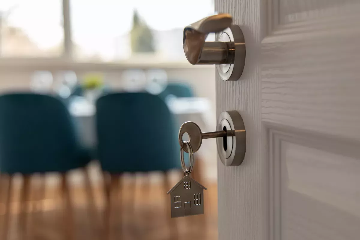 AdobeStock_333480678.jpeg key in door opening to a new home