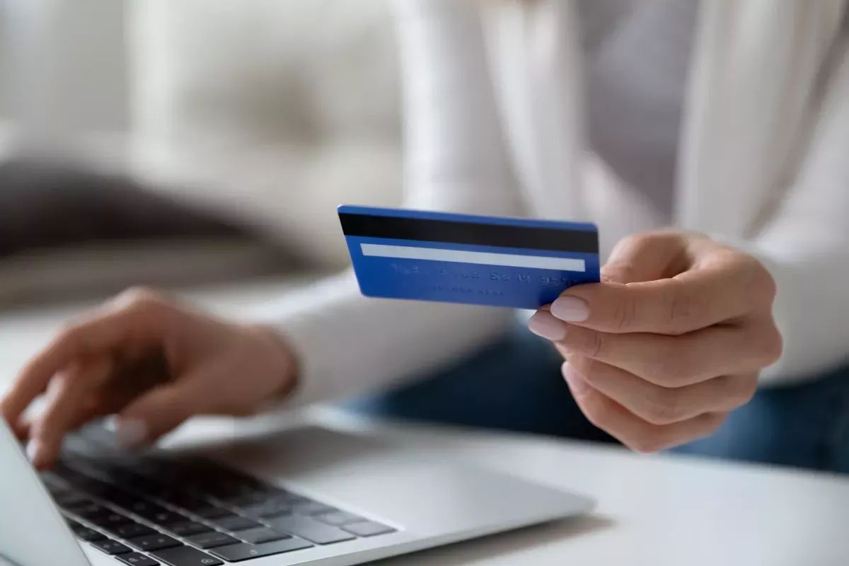 AdobeStock_359365554.jpeg close up of person using cell phone and credit card