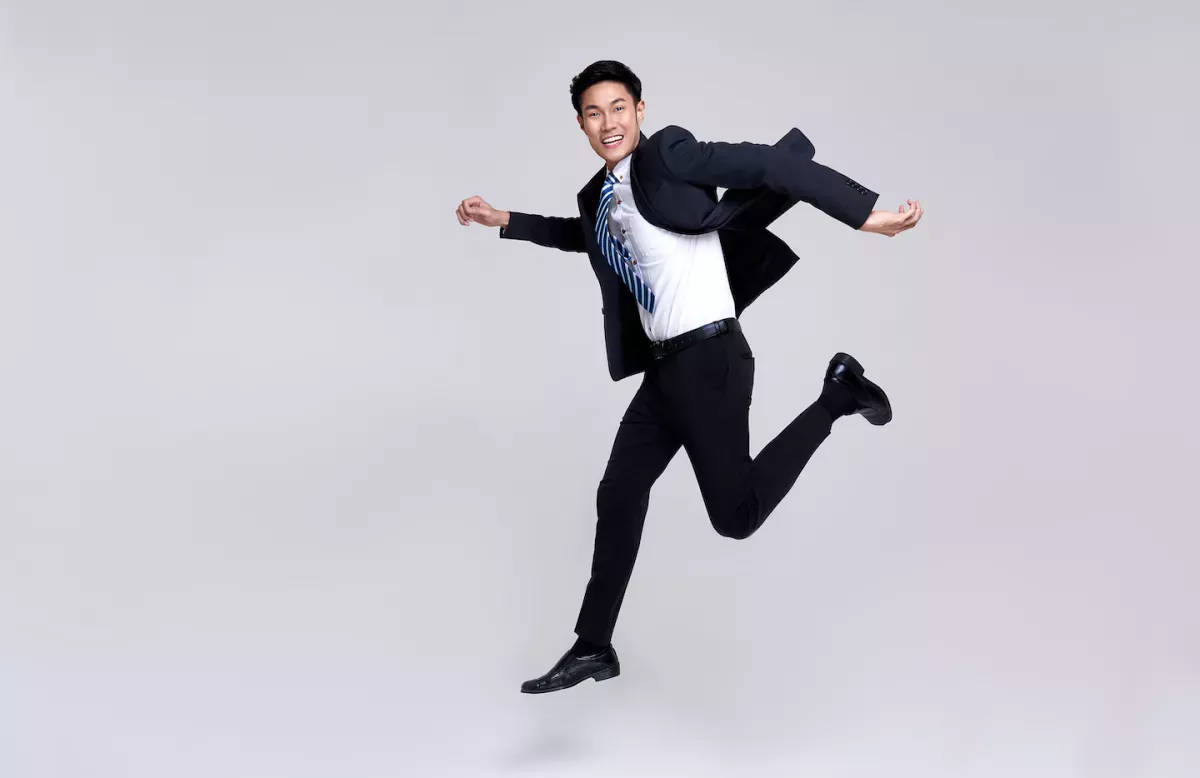 AdobeStock_406744093.jpeg Man in a suit jumping