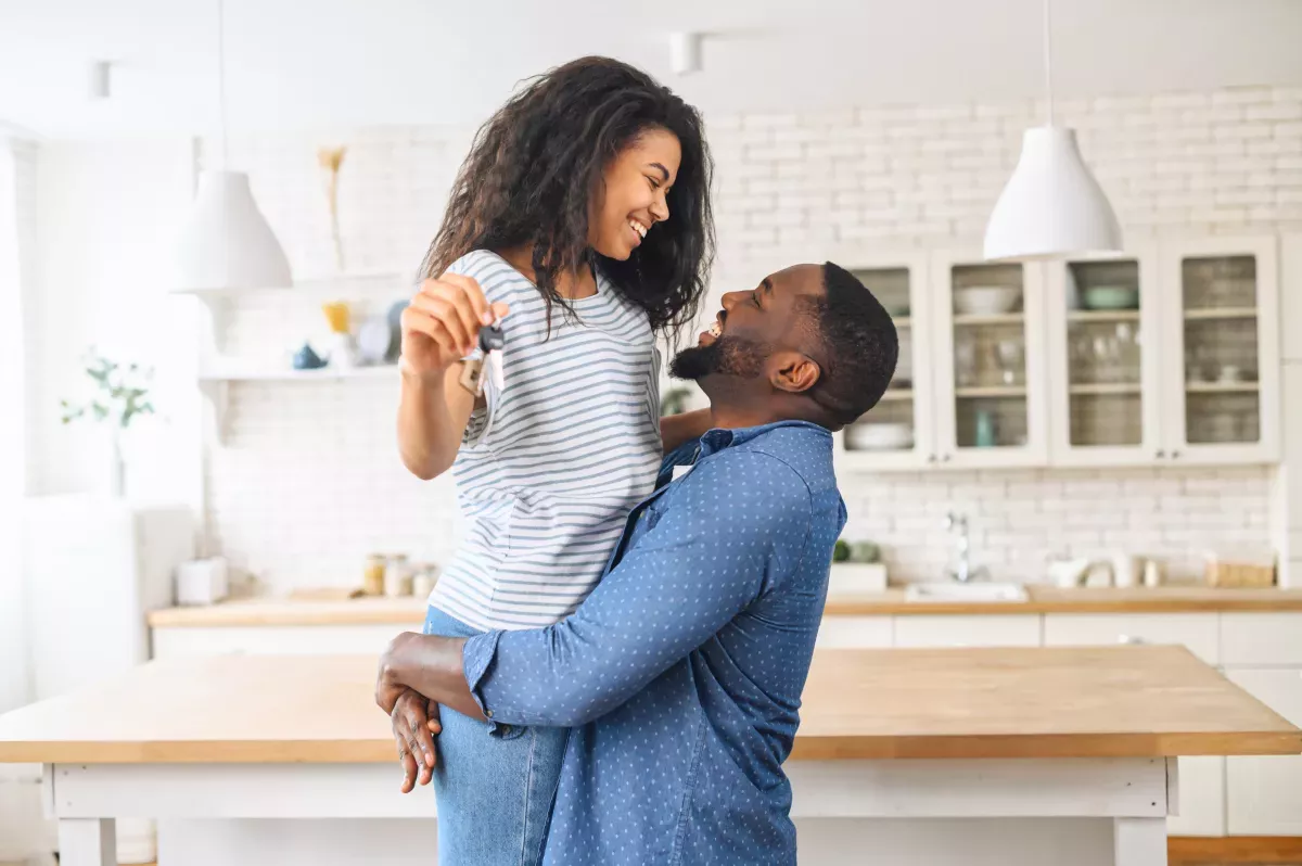 AdobeStock_425806706.jpeg excited couple in new home holding new keys and hugging