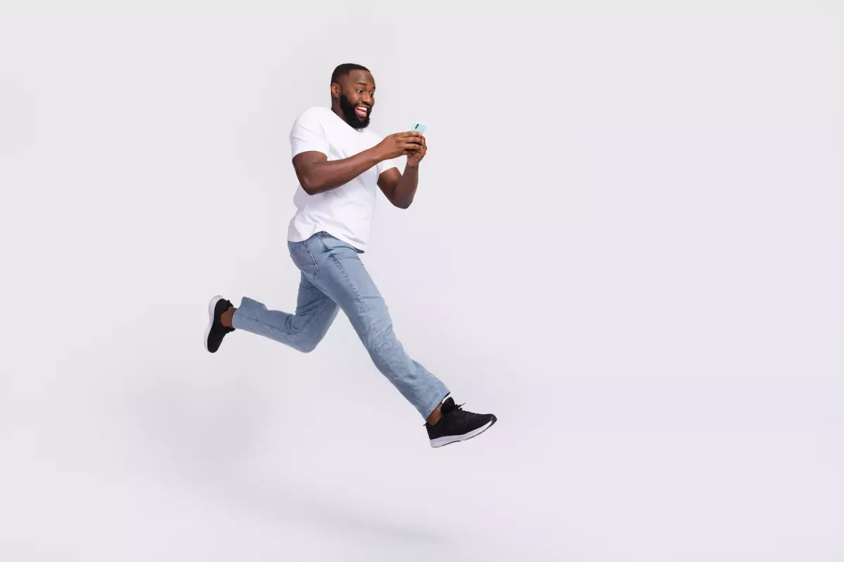 AdobeStock_504162206.jpeg Man jumping with phone