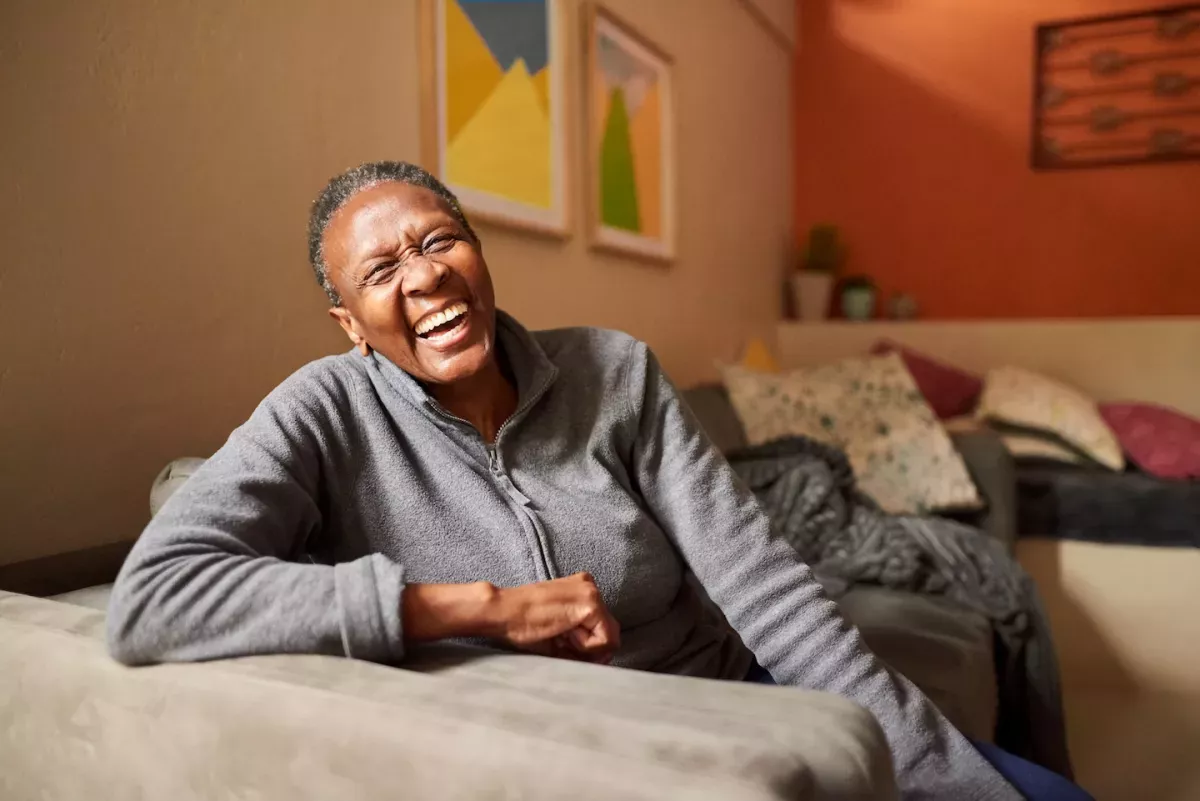 GettyImages-1303289193.jpg Woman laughing on her couch