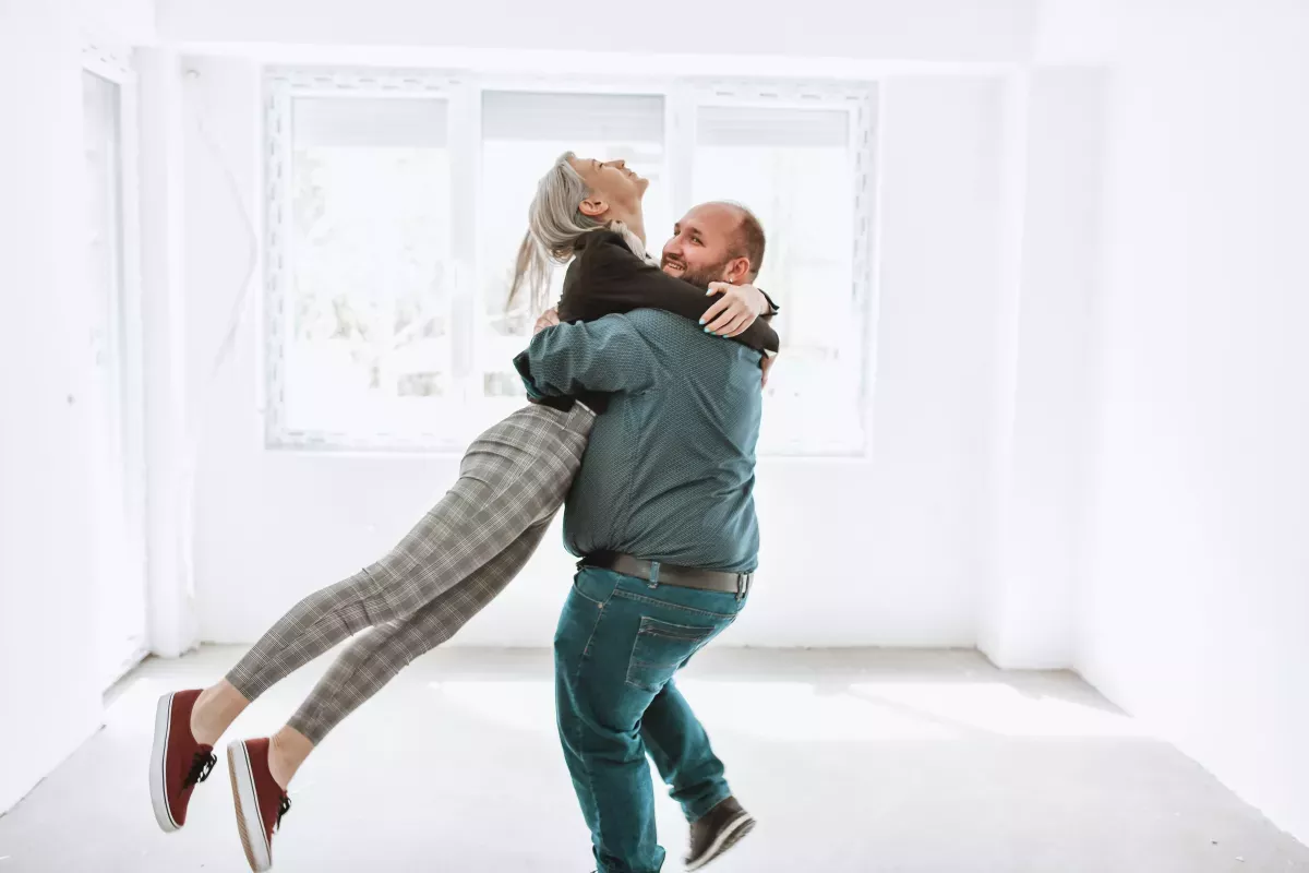 happy couple celebrating by dancing in new home