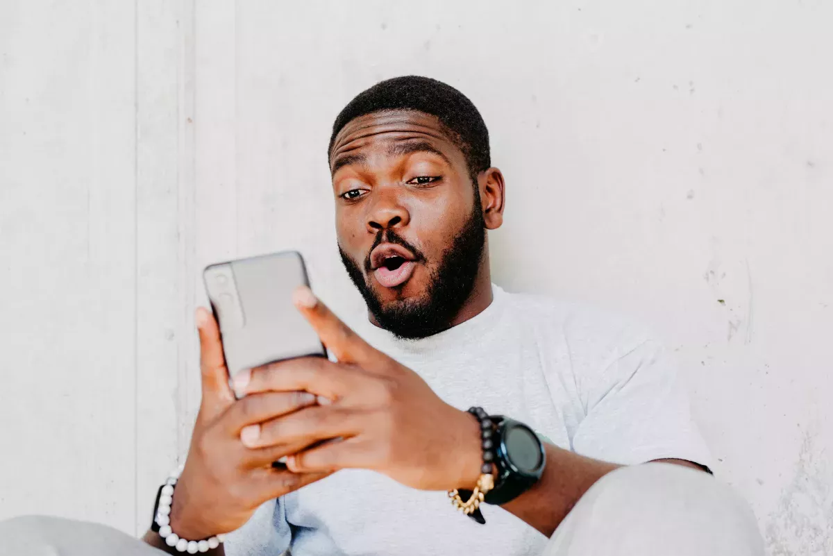 GettyImages-1332093127.jpg man with shocked expression using cell phone
