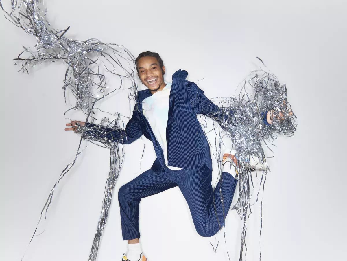 GettyImages-1355075085.jpg smiling man leaping with steamers falling all around