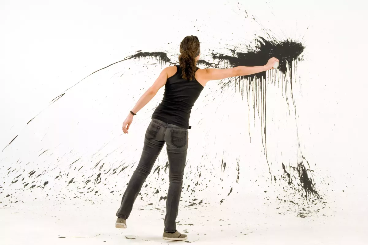 GettyImages-168511572.jpg artist throwing black paint on white wall