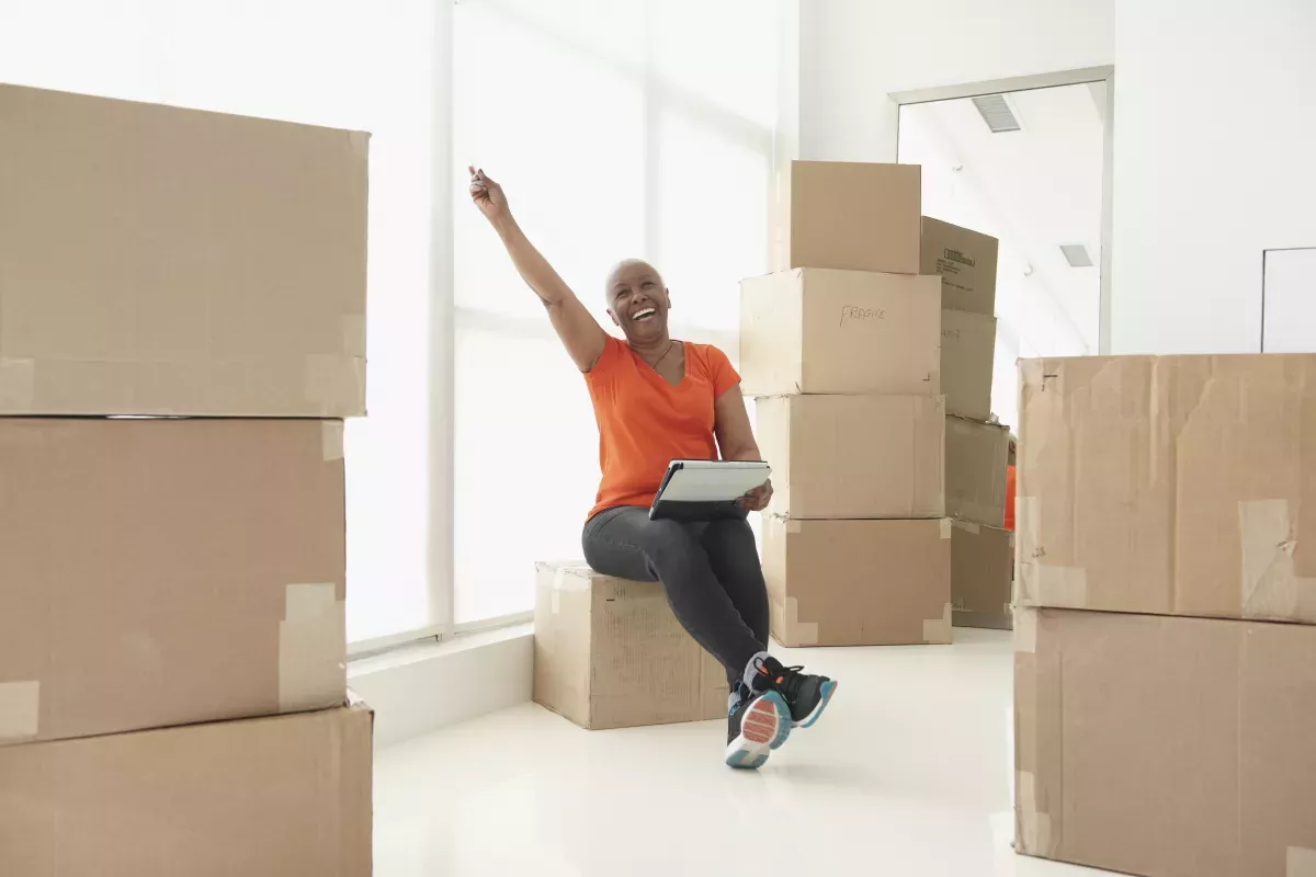 GettyImages-187139738_Scoring Strategies person sitting on moving boxes exclaiming with excitement