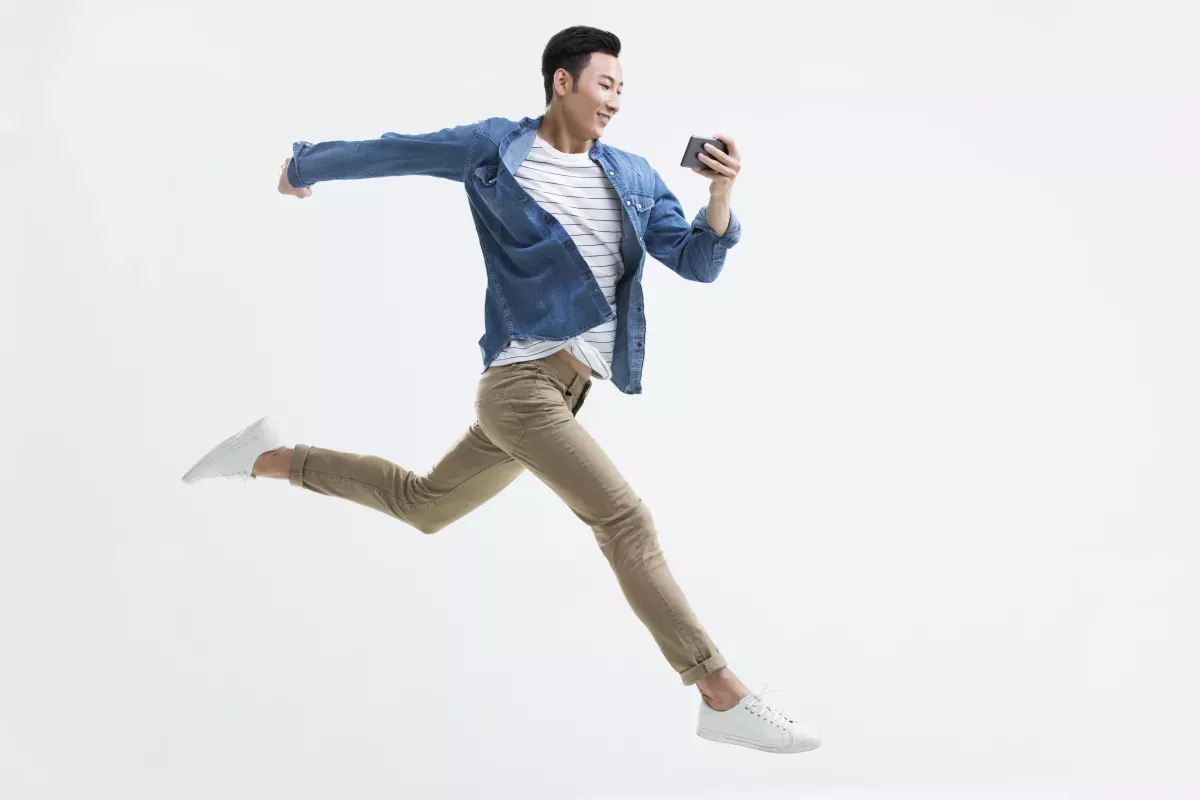 GettyImages-897620048.jpg leaping man looking at cell phone