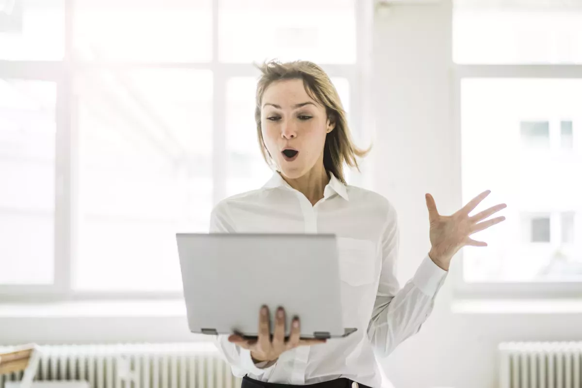 GettyImages-909597698.jpg Woman with hair blowing in the wind looking at laptop