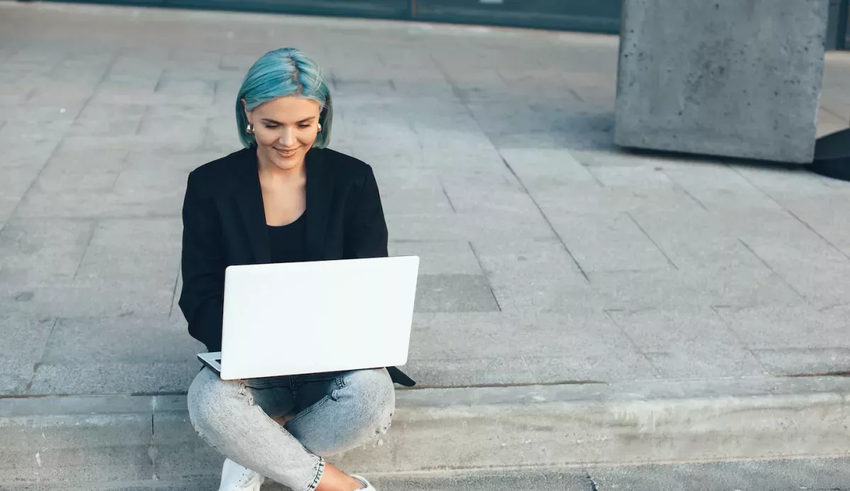 AdobeStock_332773992.jpeg Woman working outside on a laptop