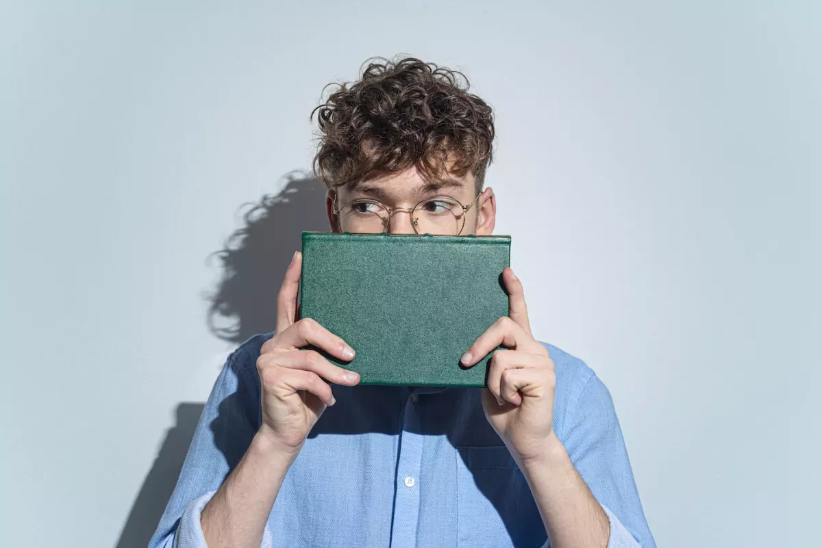 GettyImages-1295927999.jpg Man hiding behind a book
