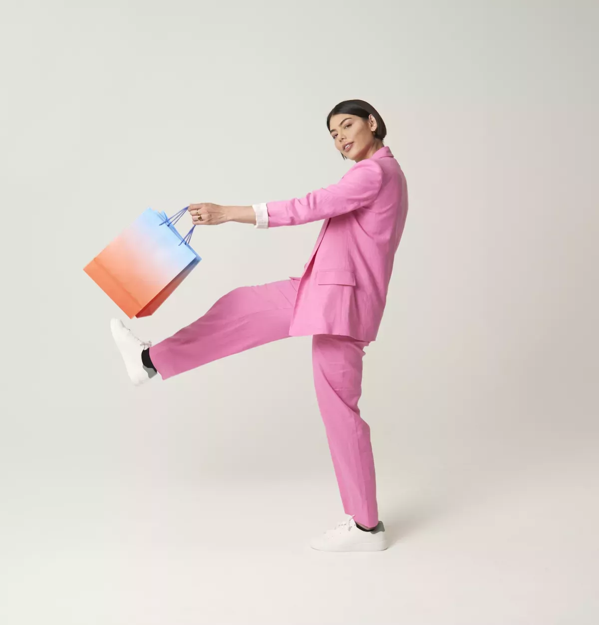 GettyImages-1415016993.jpg Woman with shopping bags jumping