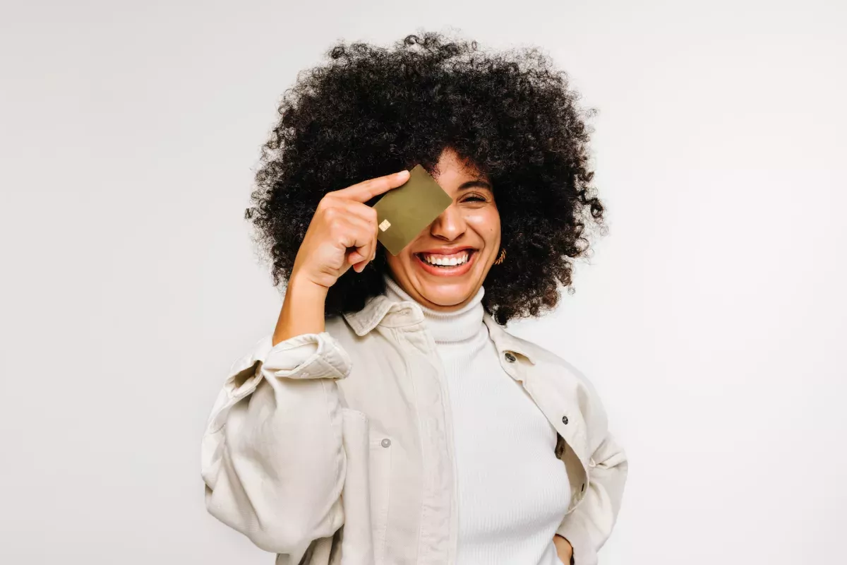 GettyImages-1441422872.jpg Woman holding a credit card over her eye