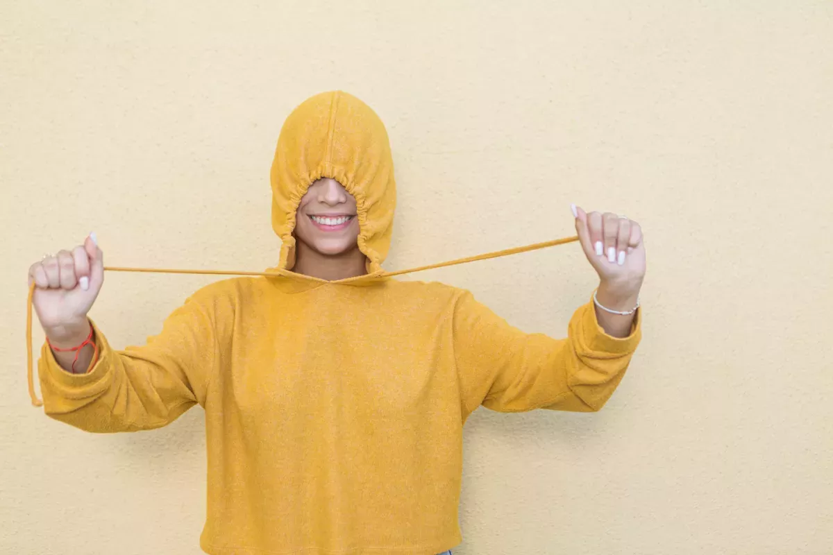 GettyImages-1455902781.jpg Woman hiding in a sweatshirt