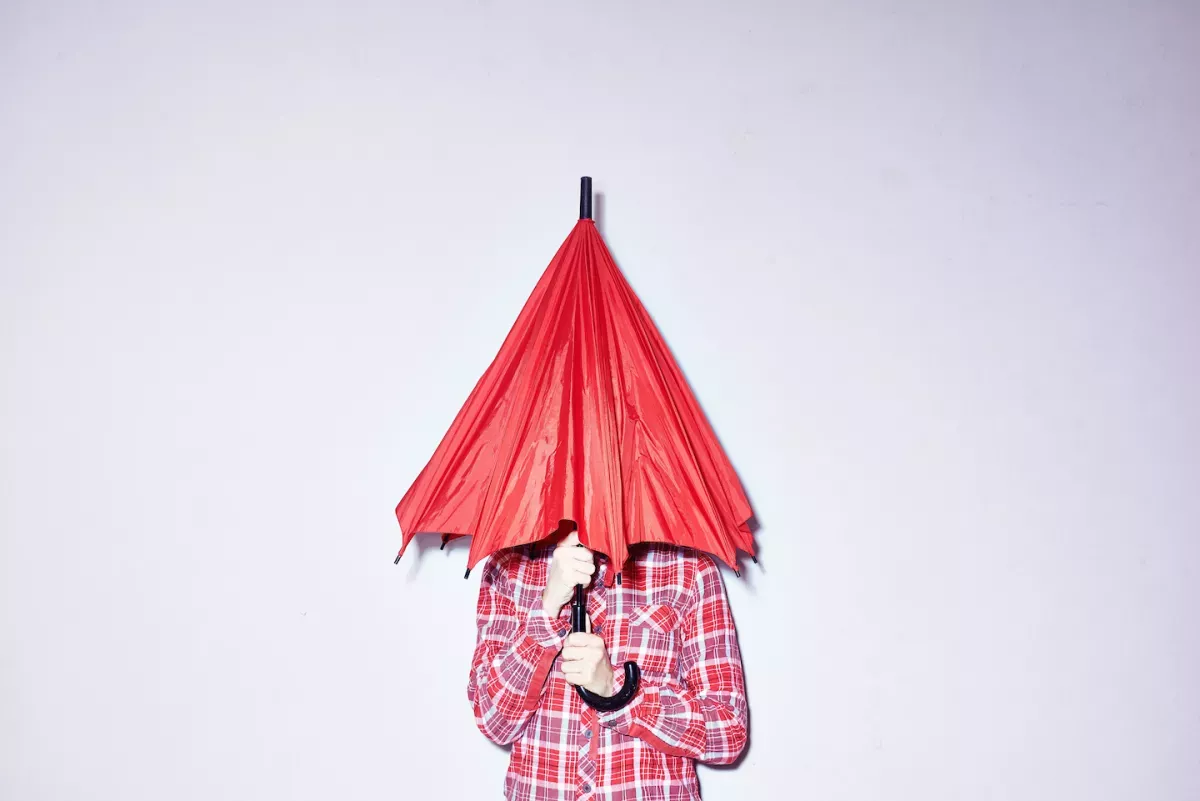 GettyImages-558945673.jpg Person hiding under an umbrella