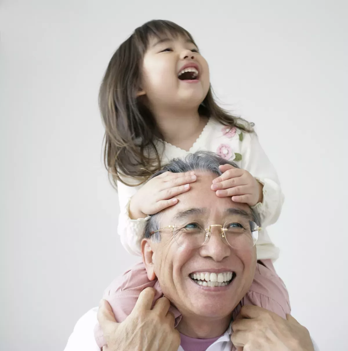 GettyImages-73819709.jpg Grandfather with granddaughter on his shoulders