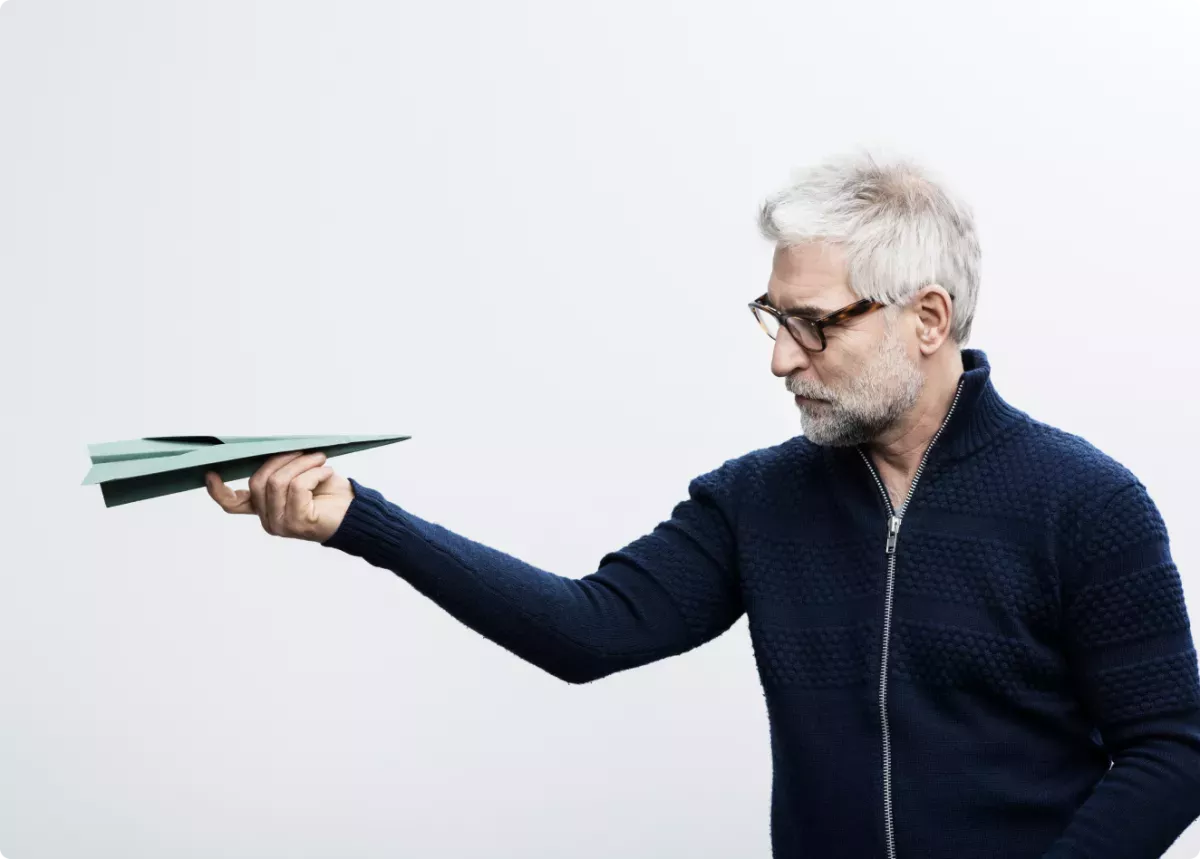 Chartis 1.png Man looking at a paper airplane