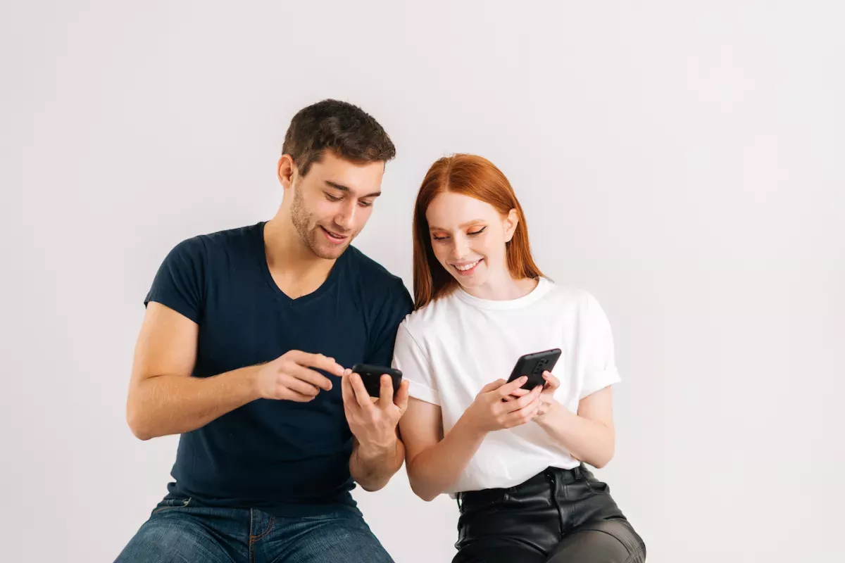 GettyImages-1368646376.jpg People looking at their phones together