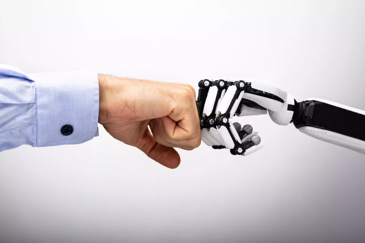 AdobeStock_229919313.jpeg human hand and robot hand bumping fists