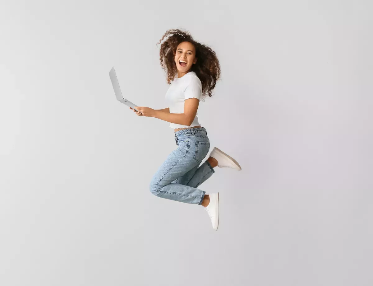 Woman jumping with laptop