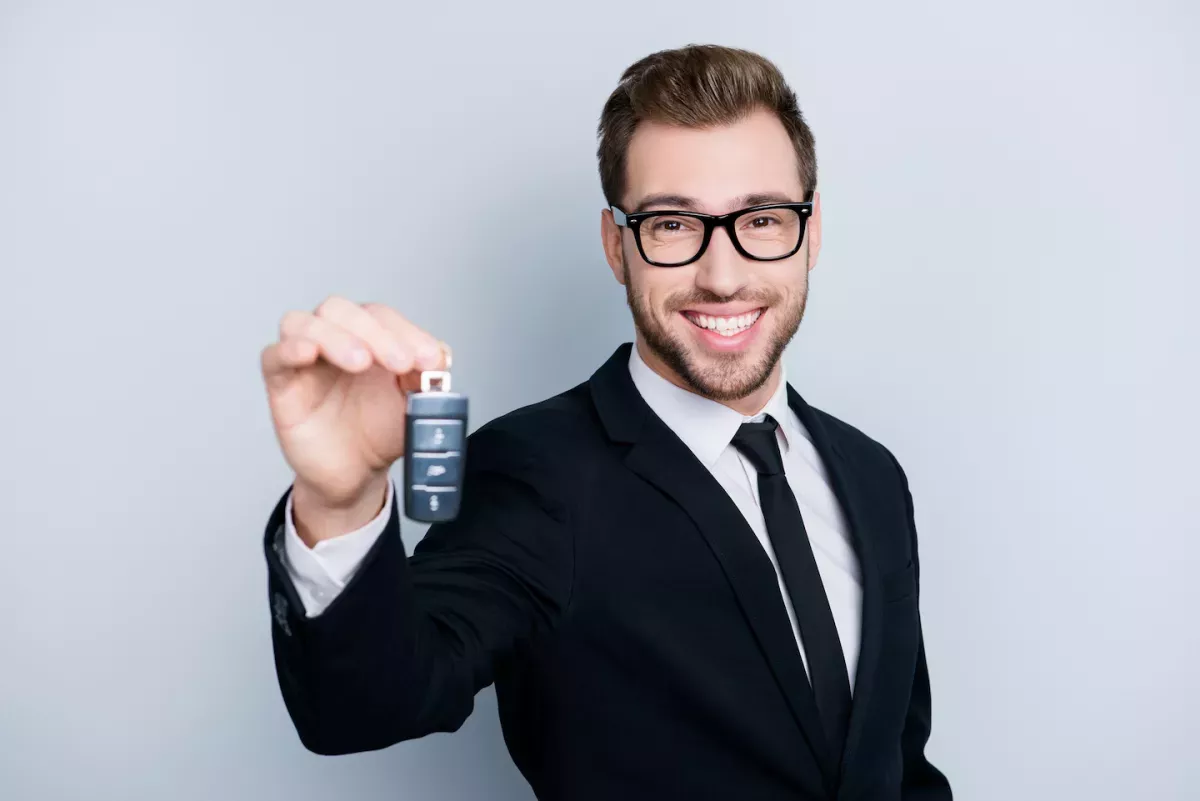 business man holding a car key business man holding a car key