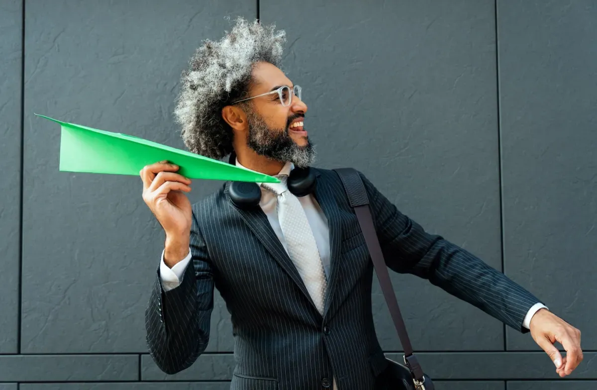 Person holding a paper plane Person holding a paper plane