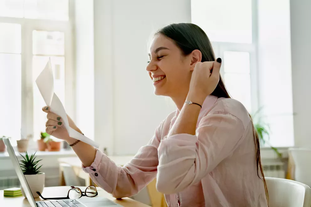smiling woman with letter in hand