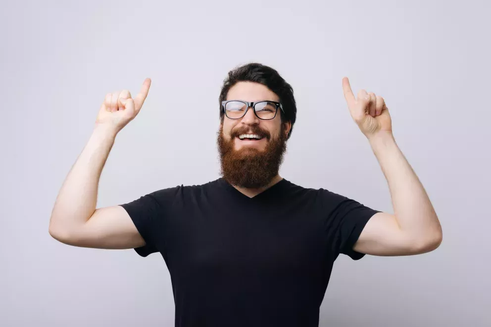 smiling man pointing up with both hands smiling man pointing up with both hands