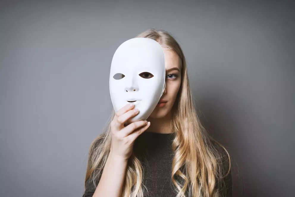 woman hiding behind face mask