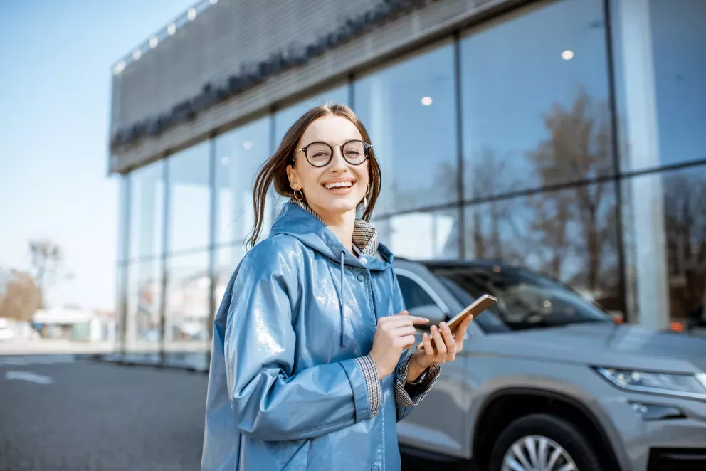 excited young woman at car dealership