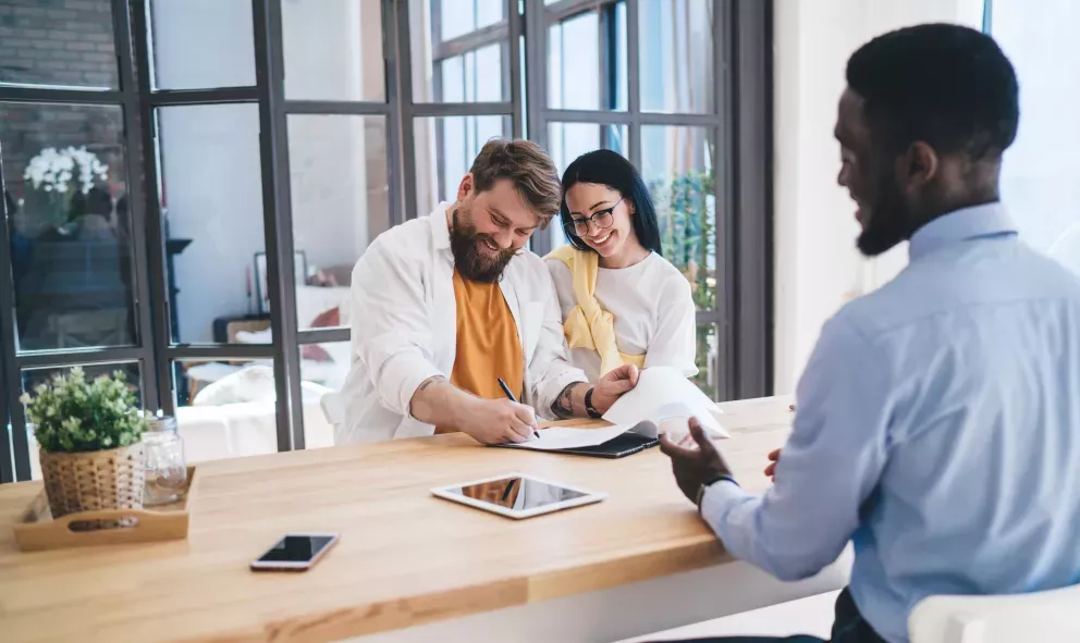 happy couple signing paperwork for new purchase