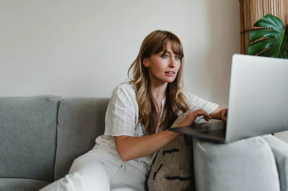 woman on couch using laptop 