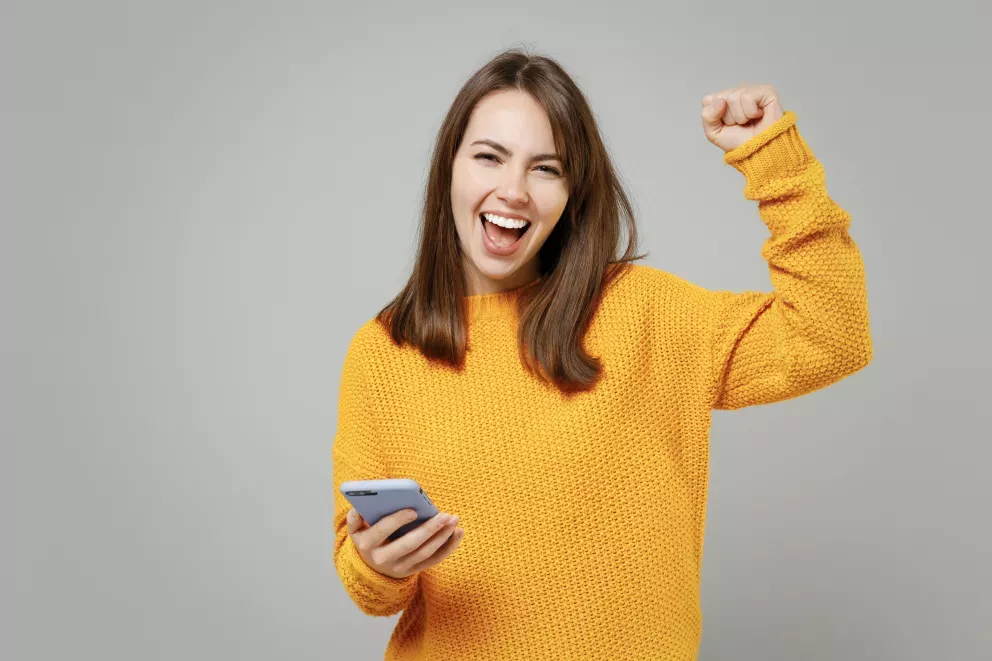 woman holding cell phone exclaiming with happiness woman holding cell phone exclaiming with happiness