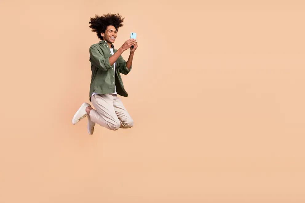 man jumping in air with cell phone in hand man jumping in air with cell phone in hand
