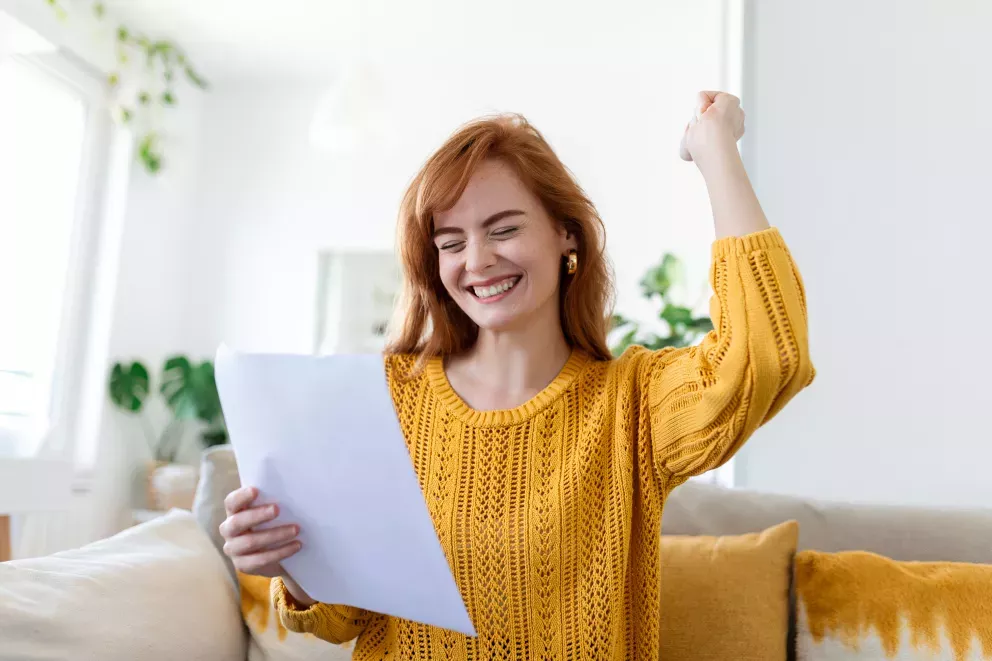 woman smiling holding letter woman smiling holding letter