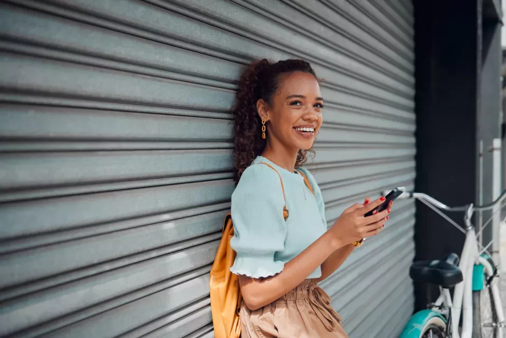 smiling woman with bike holding cell phone