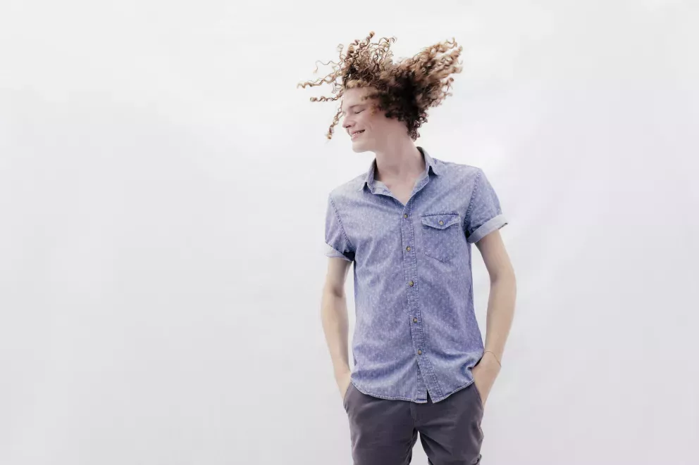 smiling man shaking hair freely through the air smiling man shaking hair freely through the air