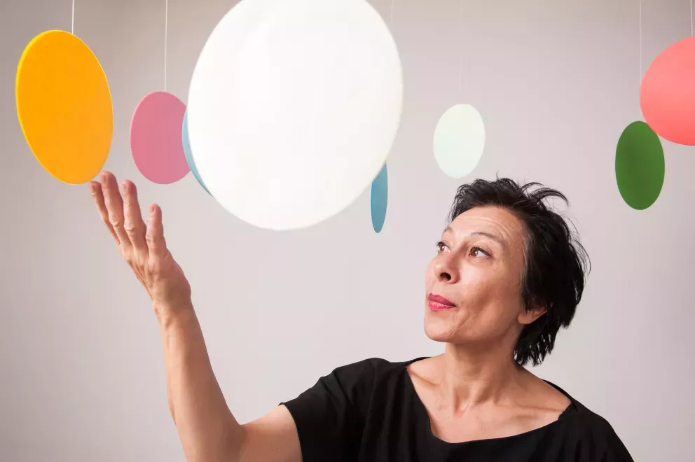 woman standing in the middle of hanging circle art pieces 