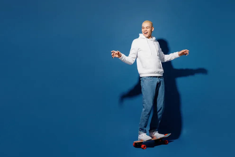 smiling man balancing on skateboard