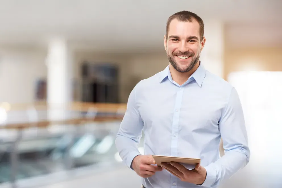 smiling man holding tablet in office