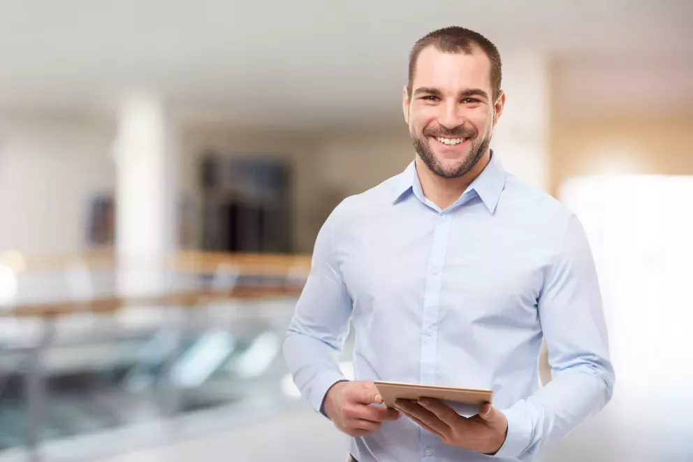smiling man holding tablet in office smiling man holding tablet in office