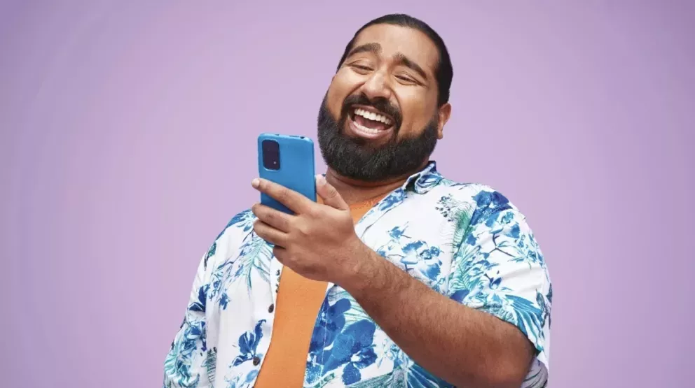 Man laughing and looking at a phone Man laughing and looking at a phone