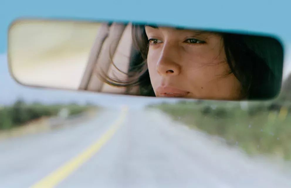 Woman looking in the rearview mirror