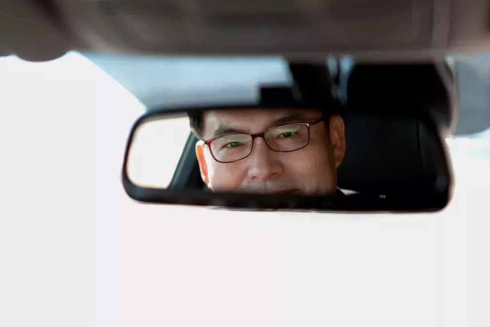 Man looking in rearview mirror Man looking in rearview mirror